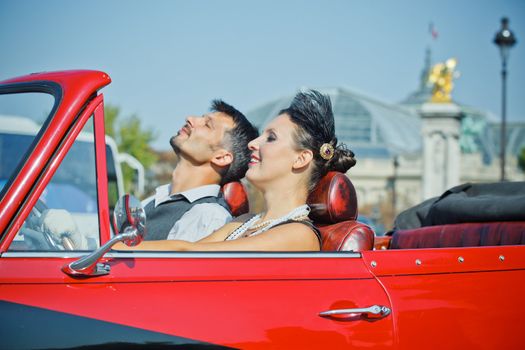 Young happy couple in retro-style travel in a car in Paris