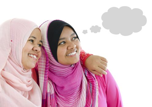 Two Muslim women having thought together, looking at side