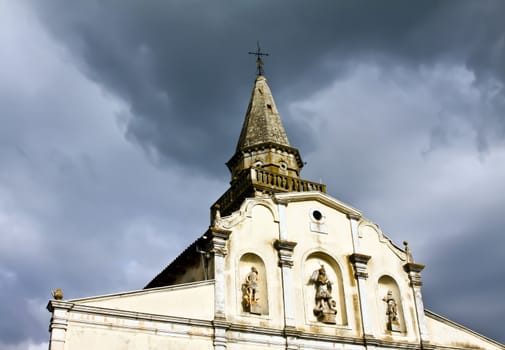 church with bell tower under black clouds