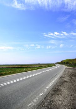Horizontal image of a country road with blue sky in the summer
