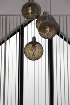 four hanging ball lights from a building roof
