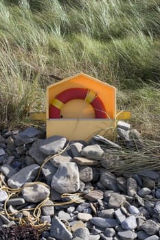 lifebuoy on rocky beal beach in county Kerry Ireland with dunes in background