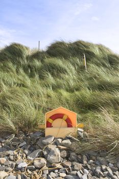 lifebuoy on rocky beal beach in county Kerry Ireland with dunes in background