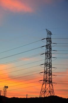 Electric power post with sunset sky background.