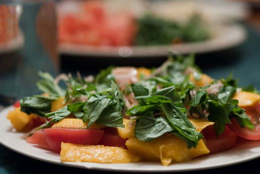 Green salad served with mango and tomatoes