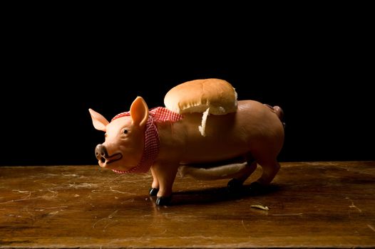 Plastic pig between hamburger buns, still life