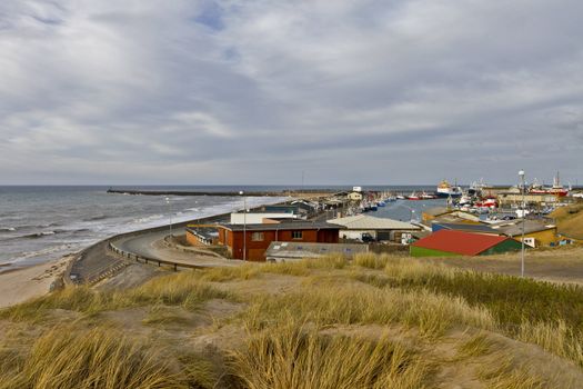 coastline in north Denmark with houses, grass and cloudy sky