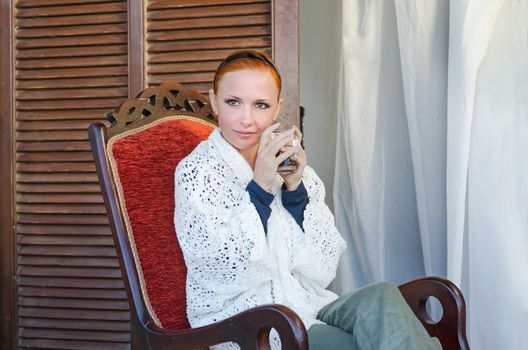 Young woman sitting on a terrace with a cup of tea