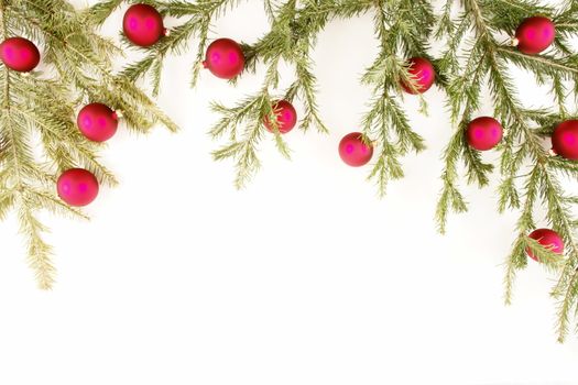 Border of red christmas garland with baubles and ribbons on white.