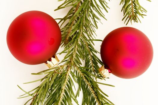 Border of red christmas garland with baubles and ribbons on white.