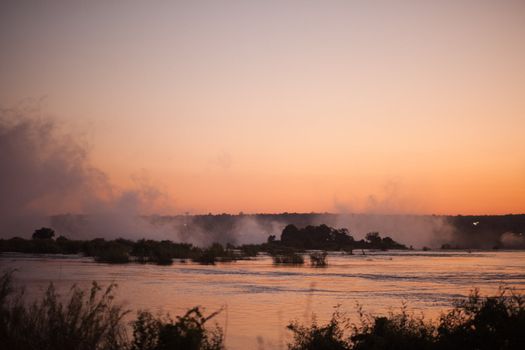 Plume of mist rising from Victoria Falls at sunset