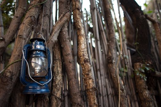 Oil lantern hanging against stick wall in African village