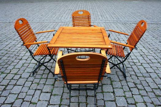 Picture of some wooden seats and tables outside..