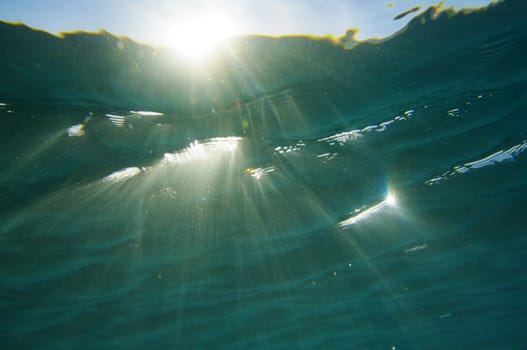 sun rays shines through water surface in the red sea