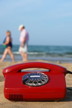 red phone on the beach on a sunny day