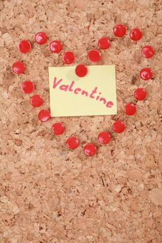 a valentine heart made of thumb tacks on a corkboard...........