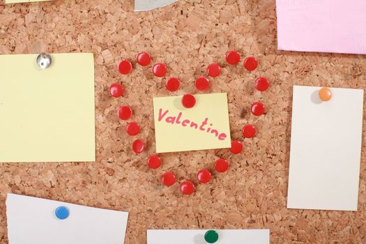 a valentine heart made of thumb tacks on a corkboard...........