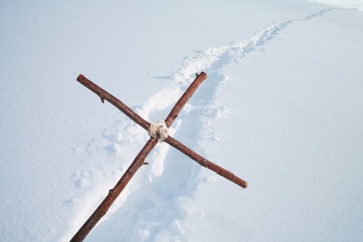 Cross in winterscene cross is showing along a path