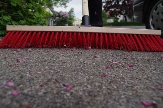 sweeping the sidewalk with a broom