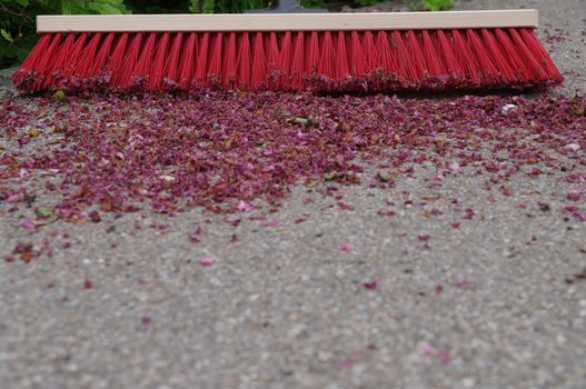 sweeping the sidewalk with a broom