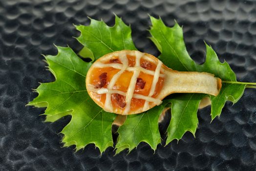 Image of a peach tart with bacon on an oak leaf