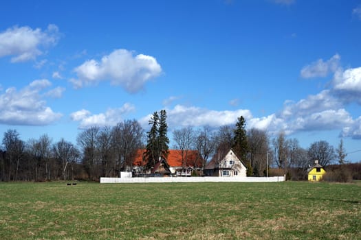 Country house on a background of the blue sky and clouds