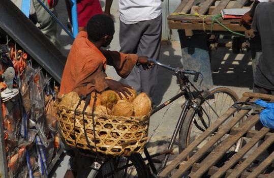 Dar es Salaam, Tanzania in July 2010: peddlers with their wares of fruit go down to the ferry that goes from Dar es Salaam to Kigamboni