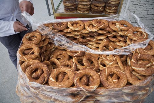 Simit vendor unpacking a new supply of fresh sesame simits in the street near Eminonu, Istanbul, Turkey.