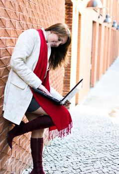 Portrait of pretty girl with laptop on the background of the city