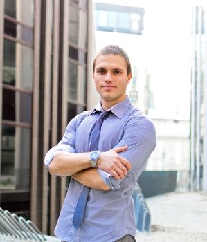 Successful man with arms folded against city backdrop