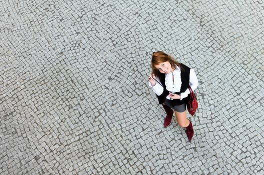 Portrait of pretty girl on the stone pavement. View from the top.