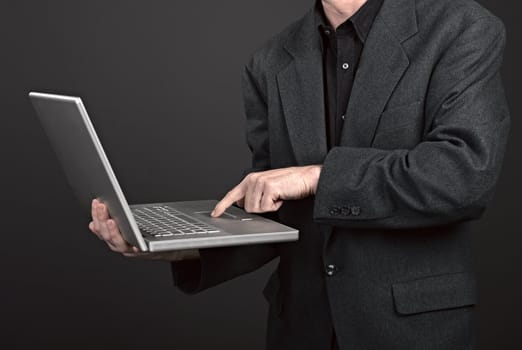 Businessman holding his laptop on black