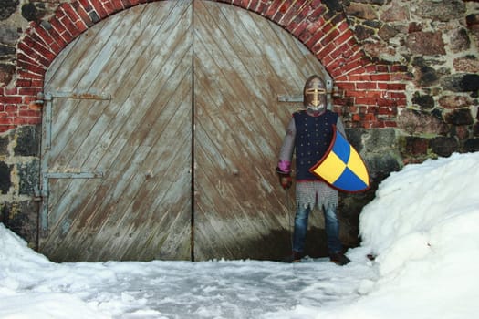 warlike knight in armor against the fortress wall