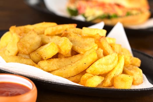 Crispy homemade French fries on metallic plate with ketchup (Selective Focus, Focus one third into the fries)