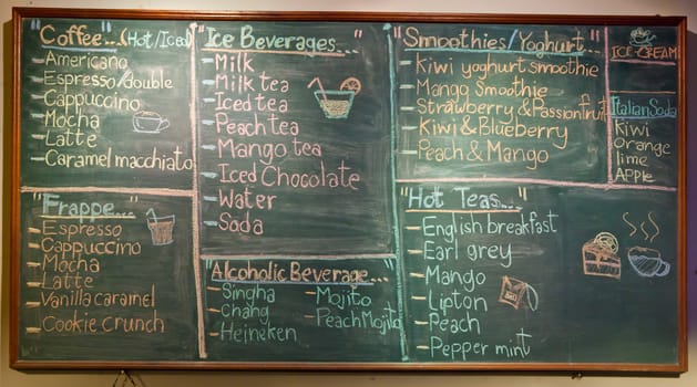 menu in front of coffee, chalk on black board: coffee, espresso, cappuccino