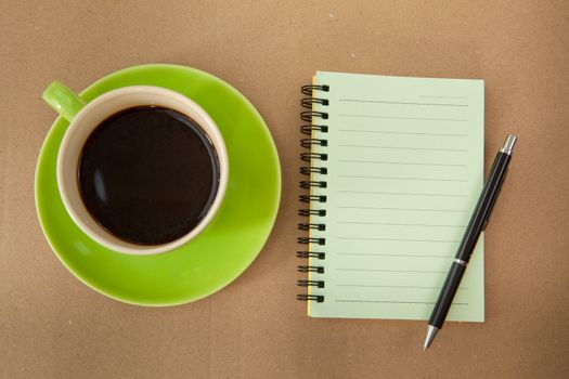 green cup of hot coffee and note paper on wood background