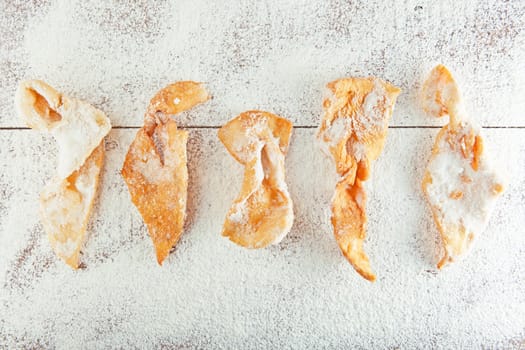 sugar-coated strips of dough fried in oil  on the wooden table