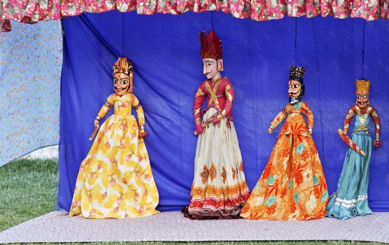 Rajasthan tribal puppet show by local tribal performers using hand crafted vividly colorful string dolls to portray historical characters, copy pace and crop margins