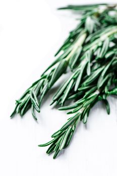 Rosmary leafs on white wooden table