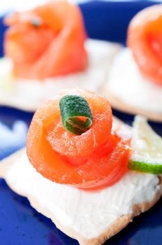 Canapes with smoked salmon and cream cheese on blue plate