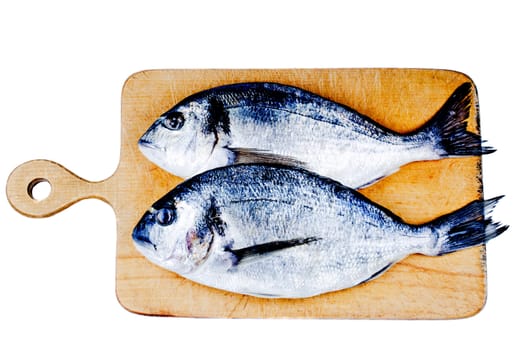 Two dorado on wooden board isolated