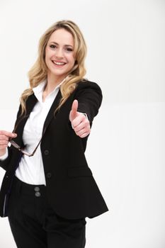 Smiling stylish blonde woman giving a thumbs up gesture of approval and support
