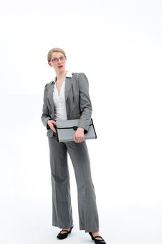 Authoritative confident businesswoman standing full length in a stylish slacksuit holding a folio file