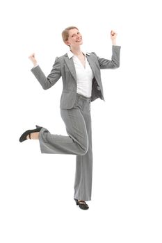 Jubilant woman in a stylish grey slacksuit dancing and punching the air with her fists isolated on white