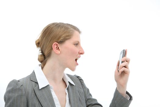 Horrified woman standing reading a text message on her mobile phone which she is holding in her hand