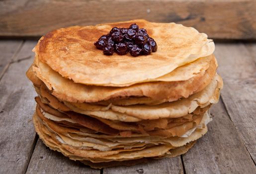 Crepes on the wooden table with cherry