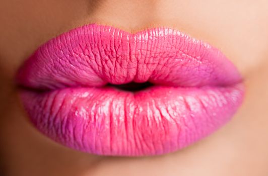 Close-up of juicy female lips with pink lipstick