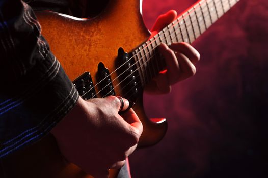 close up of hands playing an electric guitar