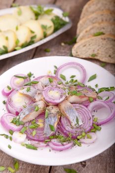Fish on  dish with onion on a wooden table
