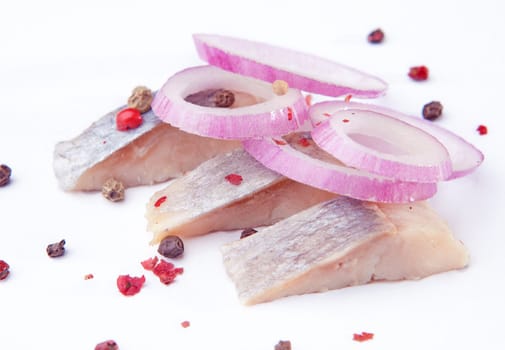 Fish with onion and pepper on a white background
